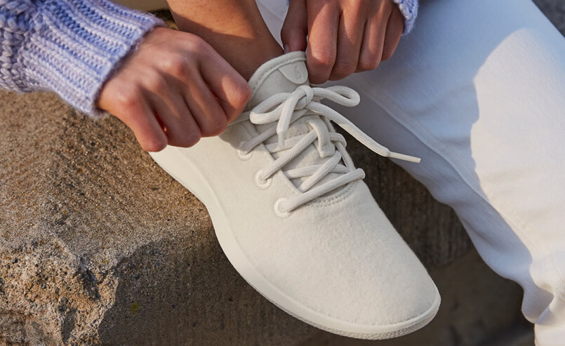 Person putting on Allbirds shoe