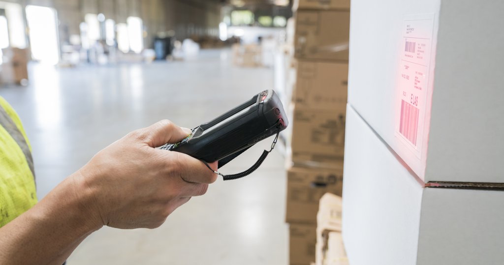 close up photo of a shipping label being scanned in a large warehouse 
